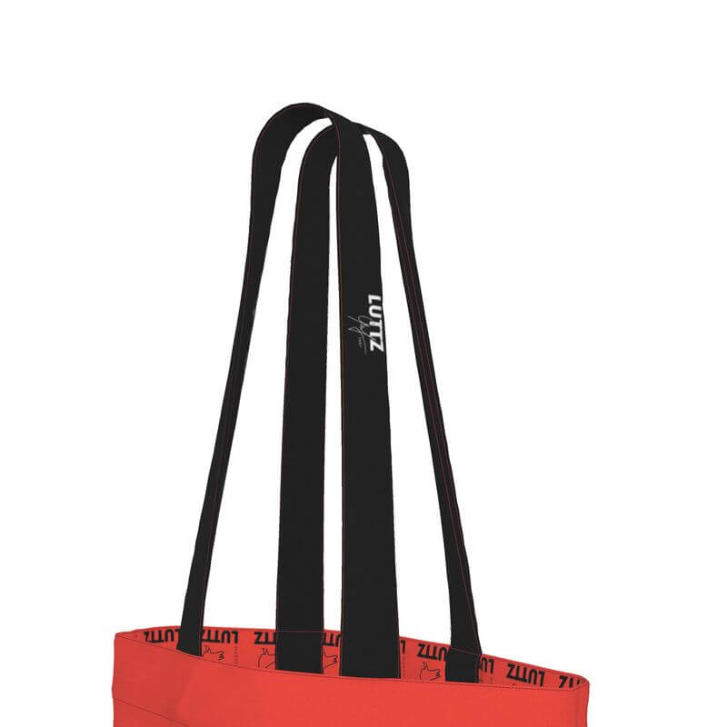 Elegant red tote bag by LUTTZ, featuring unique black straps, minimalistic design, inspired by Mediterranean colors.