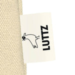 LUTTZ tag on a unique luxury tote bag, showcasing minimalist design and exclusive fabric inspired by Mediterranean style.